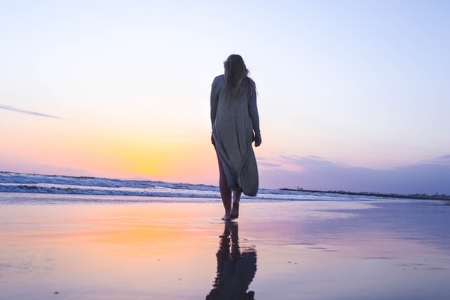 海を歩く元気のない女性