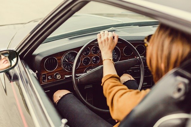 女性が車の運転をしている